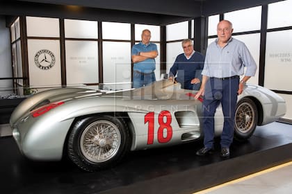 Rubén, Juan Carlos y Oscar en el Museo Fangio junto a una réplica expuesta de la legendaria “Flecha de Plata”, el Mercedes-Benz W196 con el que corrió su padre. 