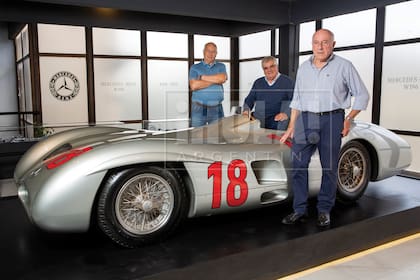 Rubén, Juan Carlos y Oscar en el Museo Fangio junto a una réplica expuesta de la legendaria “Flecha de Plata”, el Mercedes-Benz W196 con el que corrió su padre.