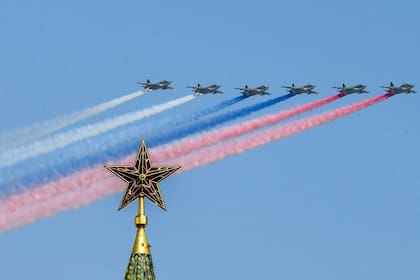 Aviones de asalto SU-25 lanzan humo con los colores de la bandera rusa mientras sobrevuelan la torre Borovitskaya del Kremlin 