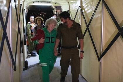 Ruth Munder, una rehén israelí liberada, camina acompañada por un soldado israelí poco después de su llegada a Israel, el viernes 24 de noviembre de 2023. (IDF vía AP)