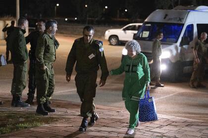 Ruth Munder, una rehén israelí liberada, camina con un soldado israelí poco después de su llegada a Israel el viernes 24 de noviembre de 2023