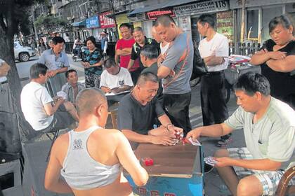 Sábado al mediodía en el barrio ruso; los hombres juegan a las cartas por dinero