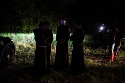 Sacerdotes locales de la Arquidiócesis de San Antonio permanecen cerca del lugar donde se descubrió un tractor-remolque con migrantes dentro en las afueras de San Antonio, Texas, el 27 de junio de 2022.