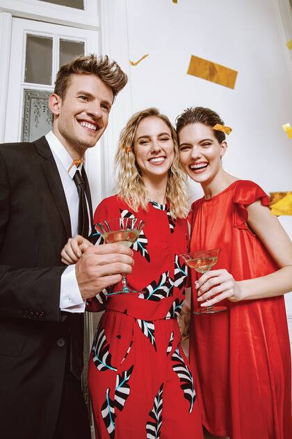 Saco negro, pantalón, camisa y corbata (Etiqueta Negra). Blusa y pantalón de seda estampada (Jazmín Chebar). Vestido de seda rojo con volados en las mangas (Las Pepas)