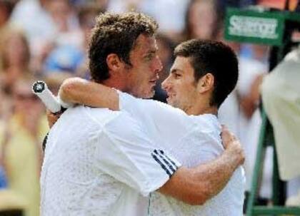Safin ya consumó su inesperada obra, la victoria ante Djokovic, y se abraza afectuosamente con el serbio, número 3 del mundo; un triunfo memorable en Wimbledon