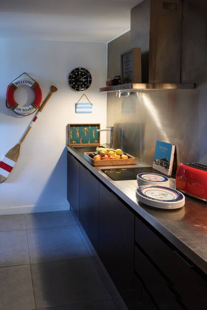 Salvavidas y remo, una bandeja con figuras de personas en traje de baño y un libro autografiado por los dueños de La Huella, de José Ignacio.