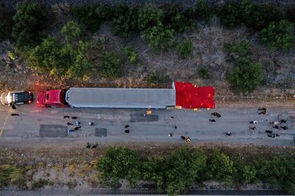  En esta vista aérea, miembros de las fuerzas del orden investigan un remolque de tractor el 27 de junio de 2022 en San Antonio, Texas. Al menos 46 personas, que se cree que son trabajadores migrantes de México, fueron encontradas muertas en un remolque de tractor abandonado