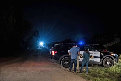 Un coche de policía está estacionado cerca de la escena en la que se descubrió un tractor-remolque con migrantes dentro en las afueras de San Antonio, Texas, el 27 de junio de 2022.