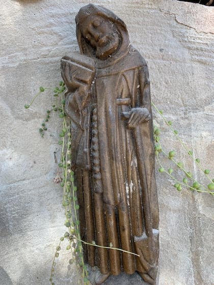 San Fiacre, patrono de los jardineros y los horticultores, representado en una estatuilla de madera, con el libro en una mano y la pala en la otra.