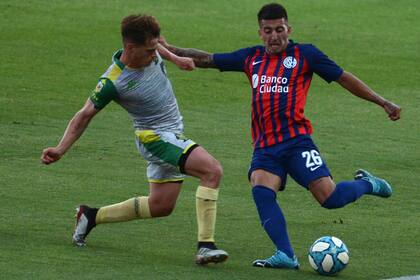 Nicolas Fernández Mercau, uno de los juveniles en el medio-campo de San Lorenzo, intenta rematar antes de que se cruce un rival