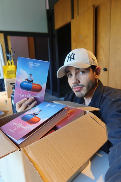 Santi Talledo junto algunos de los ejemplares de la novela que coescribió y que cuenta la historia de un joven atravesado por problemáticas de salud mental