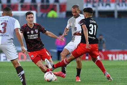 Santiago Simón disputa la pelota ante la atenta mirada de Agustín Palavecino