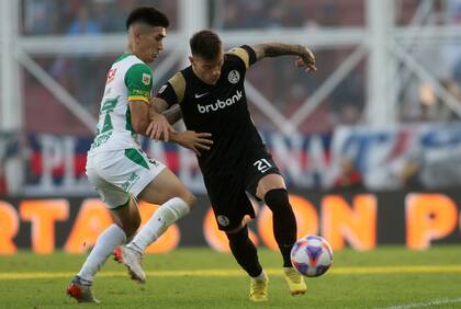 Santiago Solari intenta frenar el avance de Malcom Braida; San Lorenzo y Defensa y Justicia empataron sin goles
