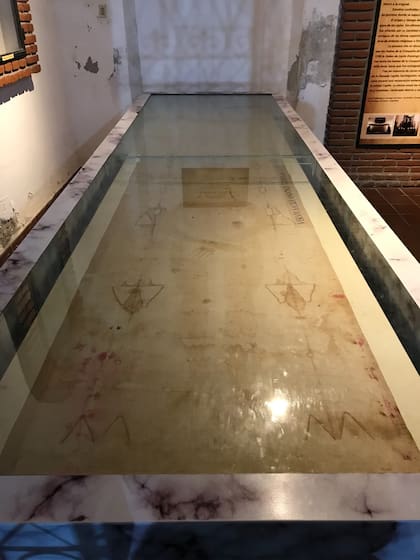 Santo Sudario con la figura de un hombre lastimado y con símbolos de deterioro físico