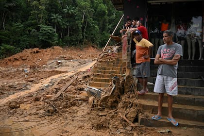 Los residentes miran una calle cubierta de barro después de que las lluvias torrenciales causaran inundaciones y deslizamientos de tierra en el distrito de Juquehy en Sao Sebastiao, estado de Sao Paulo, Brasil, el 20 de febrero de 2023