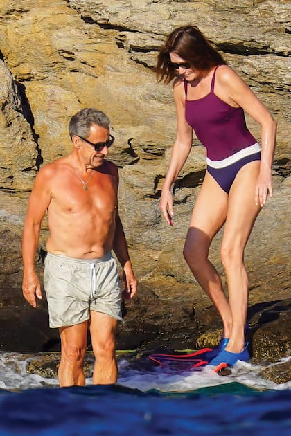 Sarkozy y Bruni –con patas de rana– se preparan para meterse al mar en busca de un poco de alivio ante las altas temperaturas.