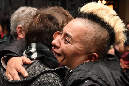 Sasha Sacayán, hermano de la dirigente trans Diana, se abraza con un amigo al momento de conocer el fallo del tribunal
