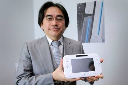 Satoru Iwata junto al gamepad de la Wii U, la consola hogareña de Nintendo