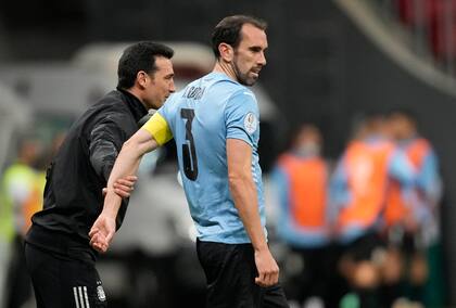 Scaloni toma un brazo de Diego Godín, el capitán de Uruguay.