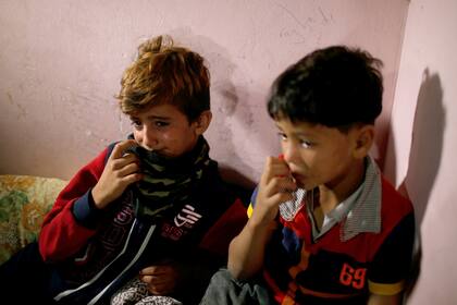 Dos niños lloran durante el funeral de su hermanita de ocho meses, que falleció tras inhalar gases lacrimógenos
