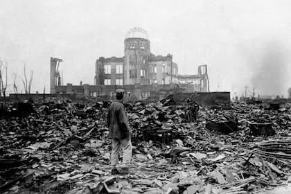 Un hombre camina sobre un mar de escombros y observa el edificio que alguna vez fue una sala de cine en Hiroshima