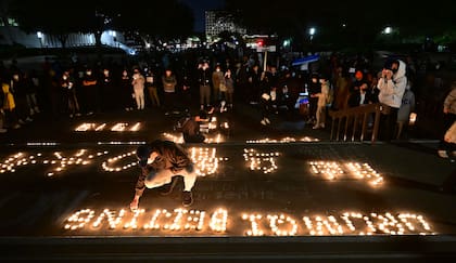 Se encienden velas mientras la gente protesta por las muertes causadas por el incendio de un complejo de apartamentos en Urumqi, Xinjiang, China, en la Biblioteca Langson en el campus de la Universidad de California, Irvine, en Irvine, California, el 29 de noviembre de 2022.
