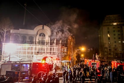 Se levanta humo mientras manifestantes iraníes prenden fuego a la embajada saudí en Teherán, domingo 3 de enero de 2016.