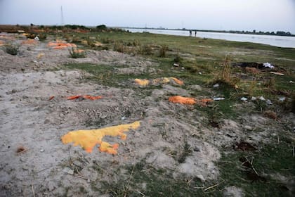 Se sospecha que víctimas del Covid-19 están parcialmente enterradas en la arena cerca de un campo de cremación a las orillas del río Ganges en Unnao, India