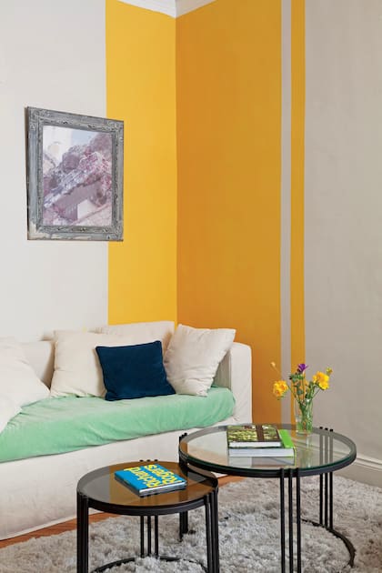 “Se tomó el ángulo para abrazar el sofá e integrar el espacio”, explica Monge que eligió el amarillo ‘6676′ de Sherwin Williams.