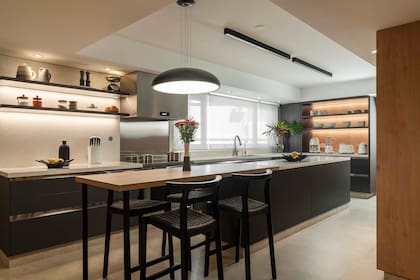 Se utilizaron apliques longitudinales y una lámpara colgante para crear un ambiente más cálido. “De noche, podés tener todas las luces apagadas y usar únicamente la luz puntual sobre la mesa y los led del desayunador”.