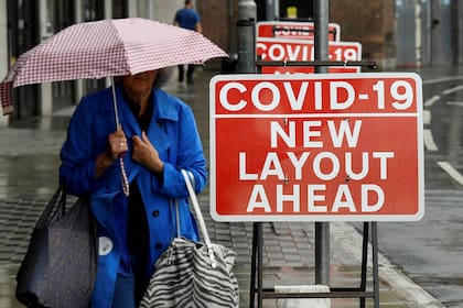 Se ve a un comprador que pasa junto a los signos de distanciamiento social después del brote de la enfermedad por coronavirus (COVID-19), en Londres, Gran Bretaña, 1 de julio de 2020. REUTERS / Toby Melville