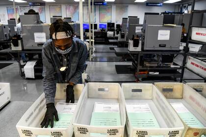 Se ve a un trabajador electoral durante el proceso de escaneo de boletas de votación por correo en el Departamento de Elecciones del Condado de Miami-Dade en Miami, Florida, el 21 de octubre de 2020