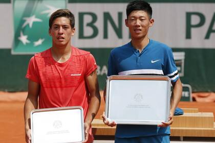 Sebastián Báez, con el premio al subcampeón en juniors de Roland Garros; a su lado, el campeón, Chun Hsin Tseng, de Taipei