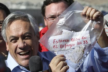 Sebastián Piñera al mostrar el mensaje de los 33 mineros que sobrevivieron en la mina San José, en el desierto de Atacama, en 2010. (AP/Hector Retamal, File)