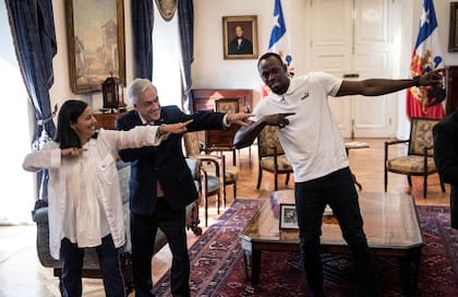 Sebastián Piñera y Usain Bolt, en La Moneda. (Martin BERNETTI / AFP)