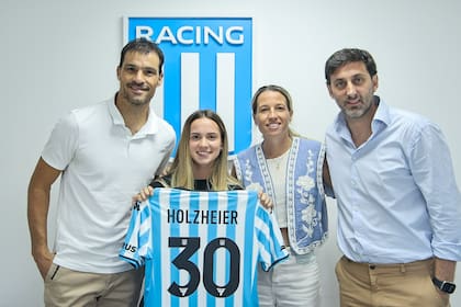 Sebastián Saja (director deportivo), Agostina Holzehier, Delfina Merino y Diego Milito (presidente), durante la presentación de la futbolista en Racing; otro paso importante en su carrera.