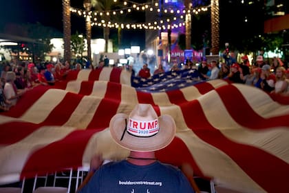 Seguidores de Donald Trump flamean una bandera de Estados Unidos en Chandler, Arizona