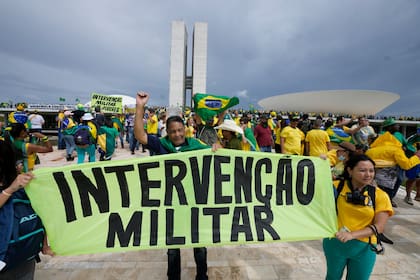 Seguidores del ex Presidente Jair Bolsonaro sostienen un cartel que dice "Intervención Militar!".