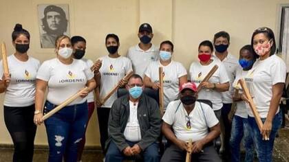 Seguidores del gobierno amenazan con palos a los potenciales manifestantes.