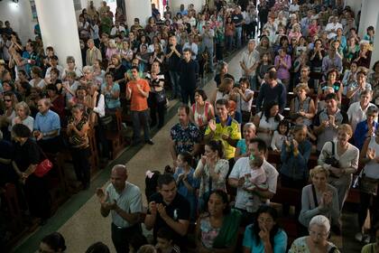 Seguidores del líder de la oposición de la Asamblea Nacional Juan Guaidó, quien se declaró presidente interino, aplauden después de que el sacerdote dijo que apoya Guaidó como presidente, durante la misa en una iglesia en Caracas, Venezuela, el 27 de enero