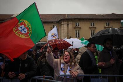 Seguidores del partido de extrema derecha Chega con banderas de Portugal durante un mitin de campaña en Lisboa