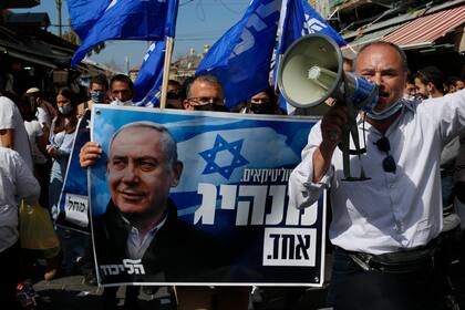Seguidores del partido Likud, con afiches con la cara del premier israelí, Benjamin Netanyahu, en un acto de campaña para las elecciones del martes