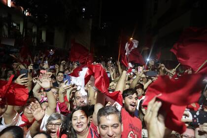 Seguidores del presidente electo del Partido Colorado, Santiago Peña, celebran tras su victoria a las afueras de su sede campaña, en Asunción, Paraguay