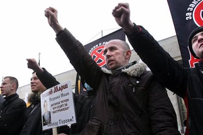 Extremistas nacionalistas rusos sostienen carteles contra los inmigrantes durante una protesta