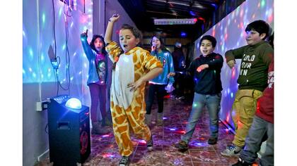 Selenna, luciendo un traje de jirafa, baila con otros niños al final de un taller de identidad de género en un centro comunitario en Santiago de Chile.