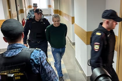 Semiel Vedel, centro, entra escoltado a un tribunal en Moscú, 24 de abril de 2023. Una corte en Rusia declaró al exagente de policía culpable de difundir información falsa sobre las fuerzas armadas por criticar la guerra en Ucrania en conversaciones con sus amigos y lo condenó a siete años de prisión (AP Foto)