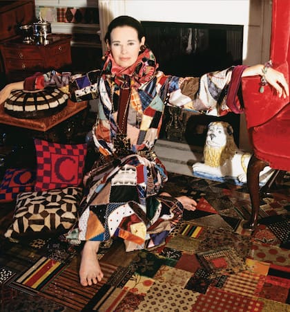 Sentada en el piso de su departamento, vestida con un caftán de patchwork de seda con cuello con volados y descalza. Era el año 1970.