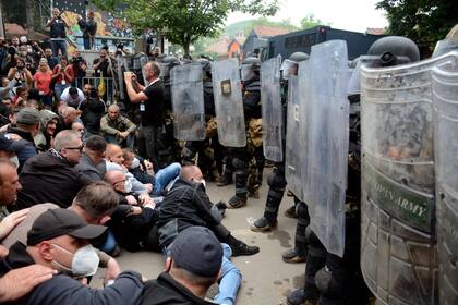 Serbios de Kosovo se enfrentan a la policía antidisturbios durante su concentración para exigir la destitución de los alcaldes albaneses recientemente elegidos frente al edificio municipal de Zvecan, en el norte de Kosovo, el 29 de mayo de 2023.