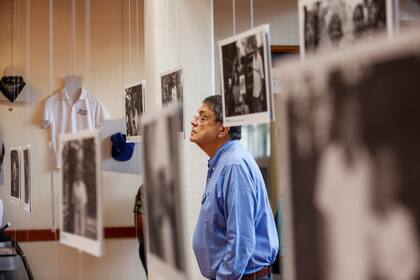 Sergio Ramírez mira una imagen durante la inauguración de una exhibición de fotografías y artículos personales que pertenecían a personas asesinadas en protestas antigubernamentales en Managua