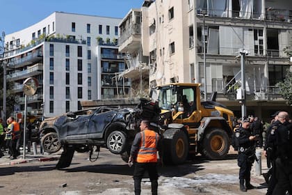 Servicios de emergencia israelíes rodean los escombros de un edificio tras el ataque de un misil iraní este martes